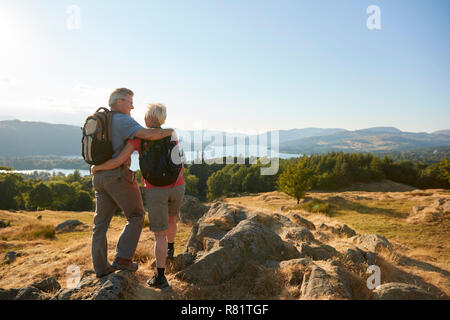 Vue arrière du Couple debout en haut de la colline sur la randonnée à travers la campagne de Lake District UK Banque D'Images