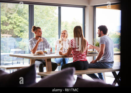 Groupe de quatre multi ethnic young adult friends talking and smiling durant une partie de dîner Banque D'Images