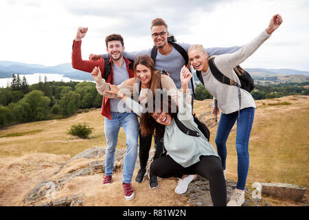 Un groupe de cinq jeunes adultes heureux amis cheer au sommet au cours de la randonnée de montagne Banque D'Images