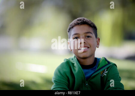 Portrait of a smiling boy sitting in a park. Banque D'Images