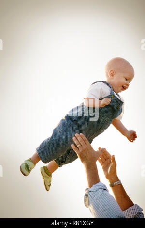 Jeune enfant qui sont en jeu dans l'air par son père. Banque D'Images