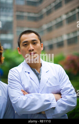 Jeune adulte homme portant une blouse de laboratoire. Banque D'Images