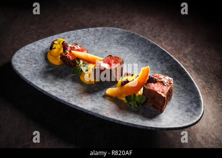 Filet de chevreuil avec purée de patate douce, carotte pourpre blanchies, confiture de coing avec du vin Banque D'Images