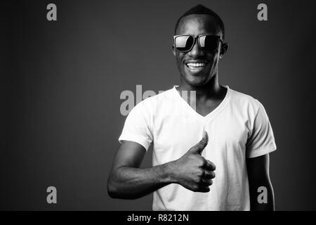 Young African man wearing Sunglasses and giving thumb up Banque D'Images