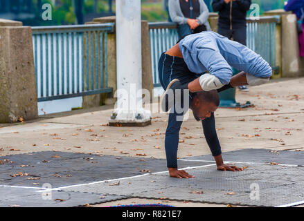 Portland, Oregon, USA - Octobre 8, 2016 : un artiste de rue ne le long des contorsions le secteur riverain de la ville dans le centre-ville de Portland. Banque D'Images