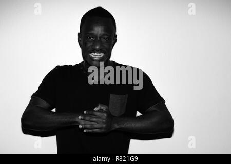 Portrait d'horreur effrayant en colère jeune homme africain en noir et blanc Banque D'Images