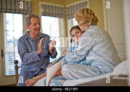 Les grands-parents avec sa petite-fille en pyjama Banque D'Images