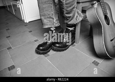 Rock and Roll concept. Bottes noires et guitare classique. Image en noir et blanc Banque D'Images