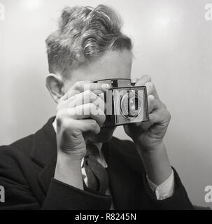 Années 1950, historique, un adolescent à l'aide d'une caméra film Paxian Paxanar-achromatique, avec un panneau avant, England, UK. Une rare et distinctif à la appareil moyen format carré avec une lentille en bakélite-tube avec un grand conseil de l'objectif, il a été fait par Braun à Nuremberg, Allemagne. Banque D'Images