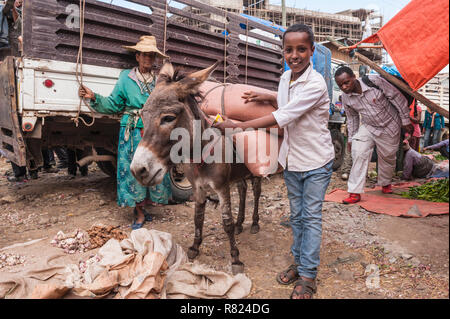 Garçon avec un pack donkey, scène de rue du marché, Mercato d'Addis Abeba, Addis Ababa, Ethiopie, région Oromia Banque D'Images