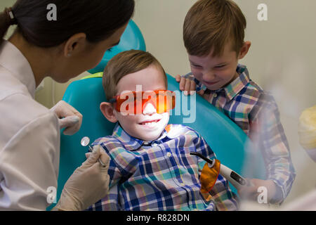 Réception à l'art dentaire. A smiling little boy jette sur la table Banque D'Images