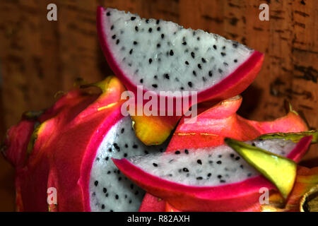 Tranche de fruit du dragon en face de l'arrière-plan de Cork , pitaya blanca ou à chair blanche et à peau rose pitaya mûr fruit également appelé Hylocereus undatus Banque D'Images