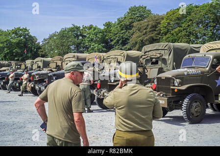 Réunion des acteurs de reconstitution historique dans American World War Deux battledresses et GMC CCKW 6x6 camions de l'Armée américaine Banque D'Images