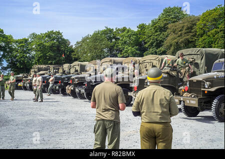 Réunion des acteurs de reconstitution historique dans American World War Deux battledresses et GMC CCKW 6x6 camions de l'Armée américaine Banque D'Images