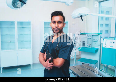Chirurgien portrait sourire décontracté homme confiant dans la salle de chirurgie, hôpital médecin porter du vert gommage chirurgie de même. background Banque D'Images