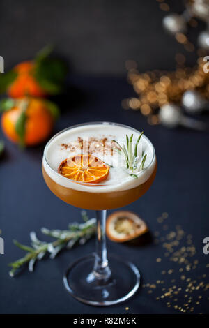 Cocktail de Noël d'amaretto sour avec clémentine déshydraté et romarin Banque D'Images