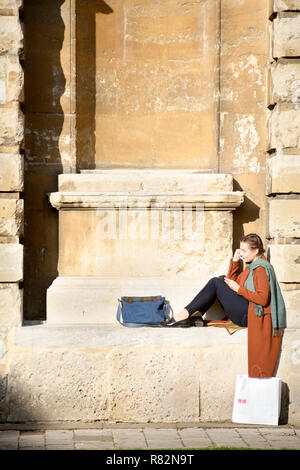 Un étudiant allongé dans une niche ou une abside à la Radcliffe Camera, salle de lecture de la Bibliothèque bodléienne de l'Université d'Oxford, UK Banque D'Images