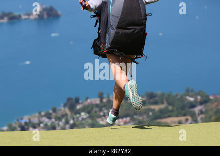 Une femme pilote parapente décollage au Col de la Forclaz, près d'Annecy, France, Lac d'Annecy avec en arrière-plan. Banque D'Images