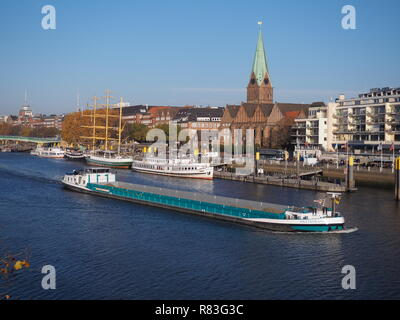 Bremen, Allemagne - 17 novembre 2018 - Weser avec waterfrontm historique navires amarrés et navire de charge passant par Banque D'Images