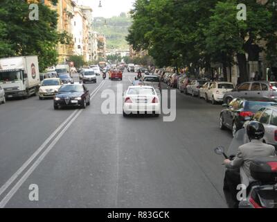 Scène de rue romain occupé, avec le tissage de trafic entre des camions, des autobus et des scooters. Banque D'Images