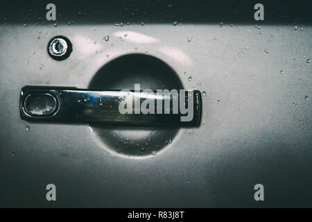 Bouton de poli sur la surface d'une voiture d'argent dans des couleurs vintage Banque D'Images