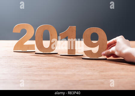 Portrait de femme 2019 réglage date fait de contreplaqué numéros sur fond noir avec table en bois Banque D'Images