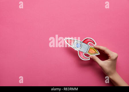 Vue de dessus du hand holding rocket sur fond rose Banque D'Images