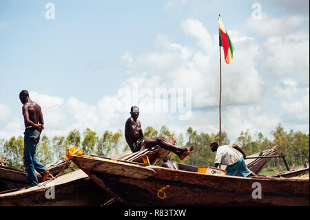 Le Mali, l'Afrique. Les jeunes hommes noirs sur l'heureux de pêche bateaux marchands de bois sur le fleuve Niger sales. Mali drapeau sur le bateau Banque D'Images