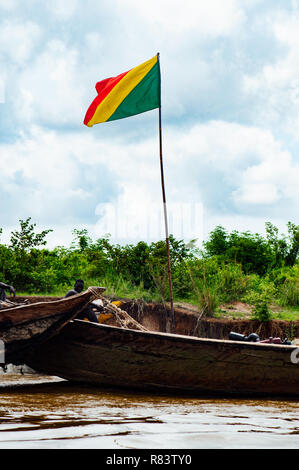 Le Mali, l'Afrique. Les jeunes hommes noirs sur l'heureux de pêche bateaux marchands de bois sur le fleuve Niger sales. Mali drapeau sur le bateau Banque D'Images