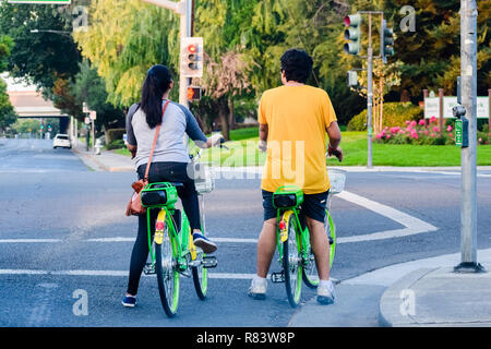 Le 3 septembre 2018 sur la montagne / CA / USA - Couple riding bikes Lime, attendant que le feu passe au vert ; la chaux est un American transportation Banque D'Images