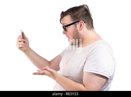 Vue de côté de l'homme obèse en parlant de lunettes via smartphone à la colère et pissé sur fond blanc Banque D'Images