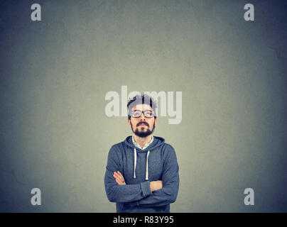 Homme barbu adultes dans les verres jusqu'à la contempler sur fond gris Banque D'Images