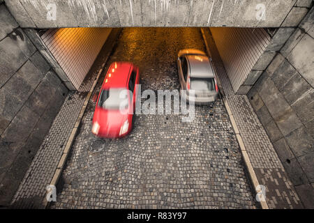 Deux voitures passanger brouillée, rouge et argent, sur la rue de galets à Varsovie, Pologne, overhead view Banque D'Images