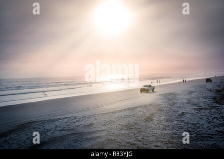 Daytona Beach avec silhouette de personnes et de voitures à cheval sur le sable Banque D'Images