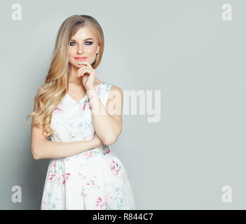 Belle jeune femme blonde penser contre white wall background with copy space Banque D'Images