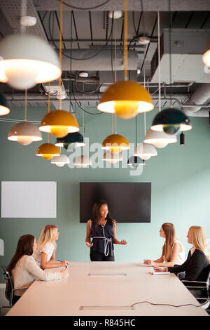 Des femmes d'affaires du groupe assis autour de table de conférence et collaborer sur des tâches de la journée d'évaluation de recrutement de diplômés Banque D'Images