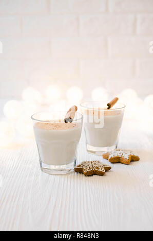 Poule maison traditionnelle de Noël et biscuits au gingembre sur fond blanc. Cocktail de lait de Noël aux épices. Focus sélectif. Copier l'espace. Banque D'Images