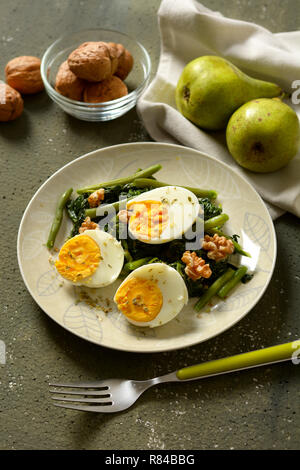 Des œufs durs avec salade d'épinards, de haricots verts et noix - libre Banque D'Images