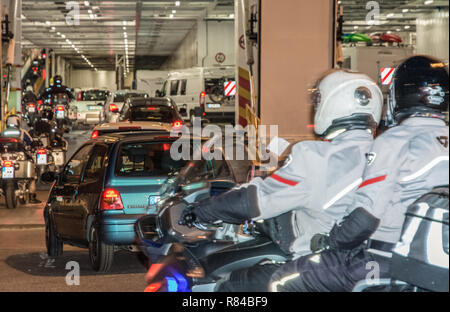 Le conseil et les motocyclistes véhicules Moby Line ferry pour l'île de la Sardaigne, en Italie, à partir du port de Livourne. Banque D'Images