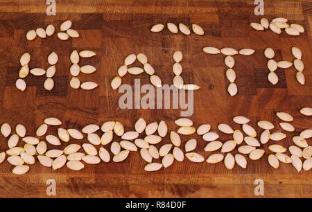 Mot "santé" énoncés de pompage sec seeds sur une planche à découper en bois. Aberdeen, Écosse, Royaume-Uni. Banque D'Images