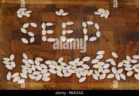 Mot 'SEED' énoncé de pompage sec seeds sur une planche à découper en bois. Aberdeen, Écosse, Royaume-Uni. Banque D'Images