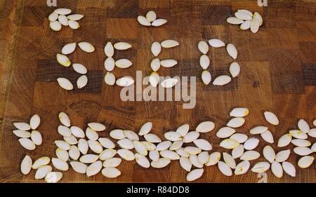 Mot 'SEED' énoncé de pompage sec seeds sur une planche à découper en bois. Aberdeen, Écosse, Royaume-Uni. Banque D'Images