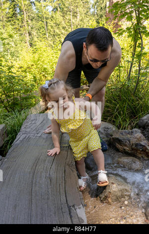 , Washington, États-Unis d'Eatonville. Il aidait son père 18 mois, fille, patauger dans l'eau peu profonde. (MR) Banque D'Images