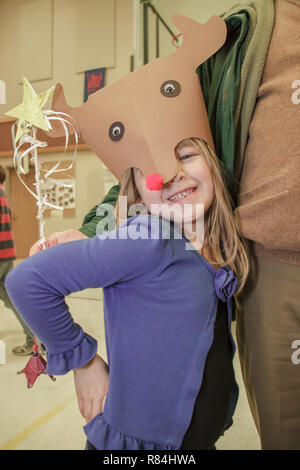 Six ans, fille, exhibant son handmade Rudolf hat dans une école de l'artisanat permanent juste par son grand-père. (MR) Banque D'Images