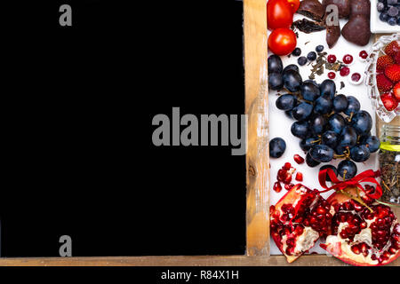 L'alimentation riche en resvératrol, raisins, prunes, Fraise, Chocolat noir,Grenade, la canneberge,thé vert dans un bocal en verre, de tomates, de bleuet copy space Banque D'Images