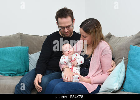 Emily et James mari Chris James avec leurs deux mois Harvey à leur maison dans la région de Cambourne, Cambridgeshire. Banque D'Images