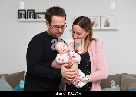 Emily et James mari Chris James avec leurs deux mois Harvey à leur maison dans la région de Cambourne, Cambridgeshire. Banque D'Images