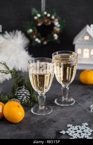 Deux verres de champagne à fond gris, les guirlandes, les mandarines, cônes et près de jouets de Noël. Composition de Noël Banque D'Images