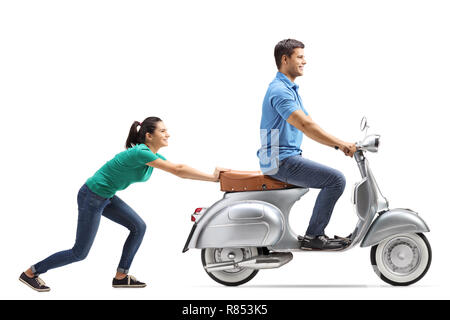 Tourné sur toute la longueur d'une jeune femme poussant un gars sur une moto vintage isolé sur fond blanc Banque D'Images