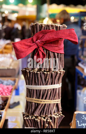 La réglisse bâtons de réglisse (brutes) Glycyrrhiza glabra avec un archet rouge de Noël sur un étal à Borough Market à Londres Angleterre Royaume-uni Noël KATHY DEWITT Banque D'Images